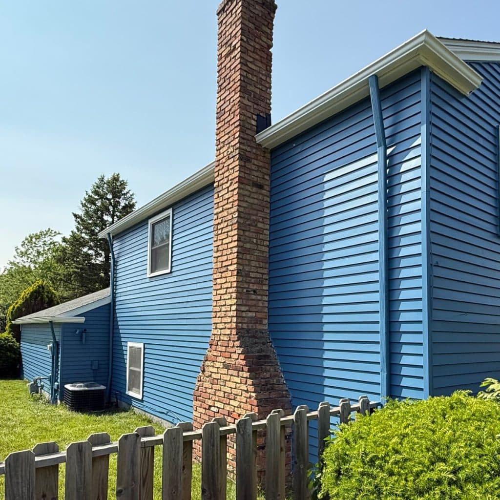 exterior-house-painting-strongsville-oh-siding-painting-after-05 Exterior house painting Strongsville OH — rear of house with new blue siding and chimney after full repaint